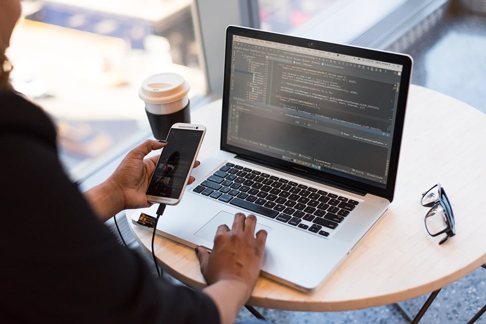 Person looking at a phone and laptop screen