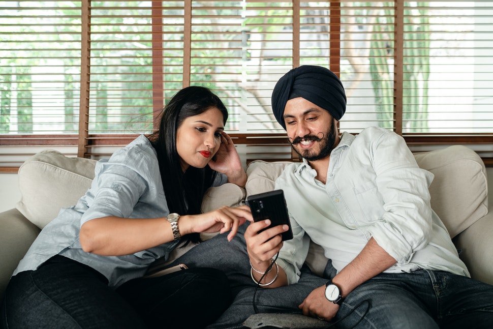 A couple at home looking at a smartphone