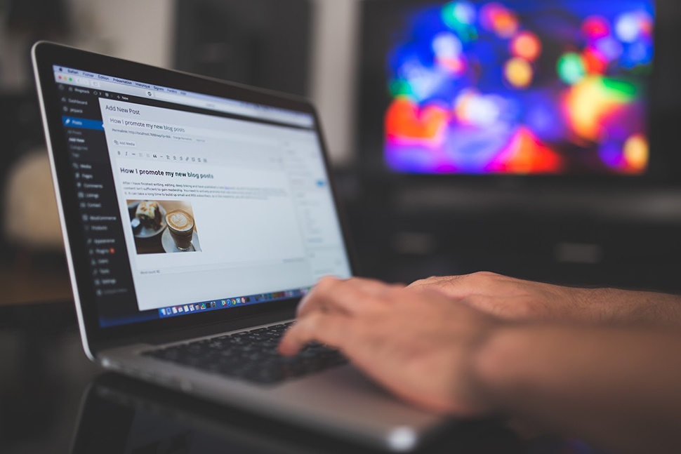 Someone typing on a laptop keyboard with the screen visible to the camera.