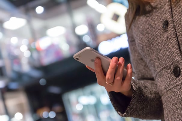 Woman holding a smartphone in a shopping center
