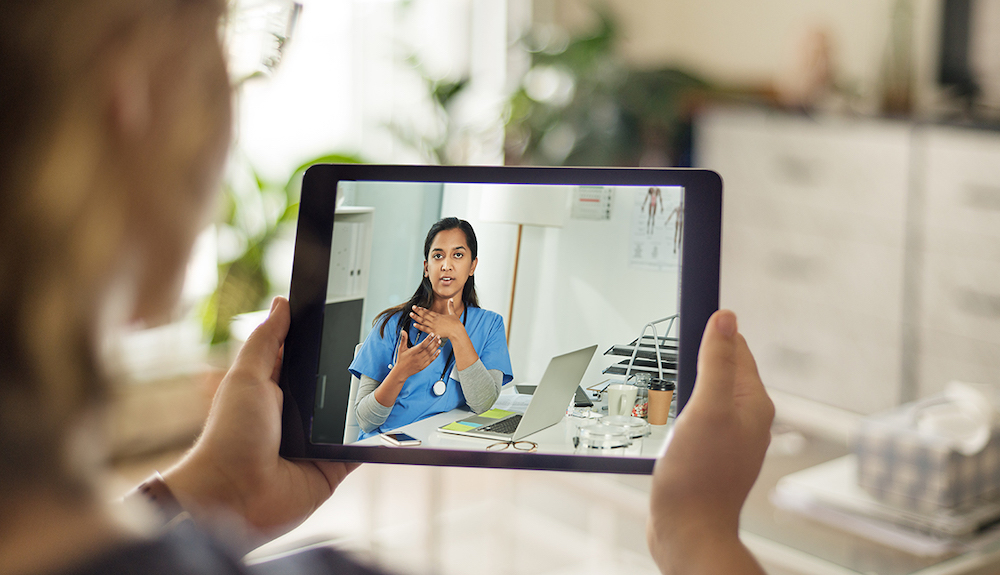 Physician speaking virtually with patient via tablet